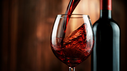 Detail of pouring red wine into glass - obrazy, fototapety, plakaty