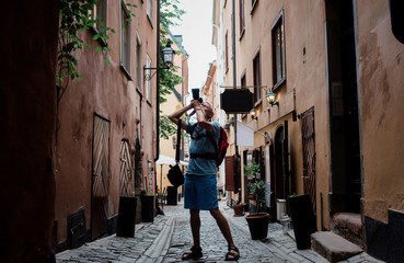 older man taking pictures with dslr travelling in Europe