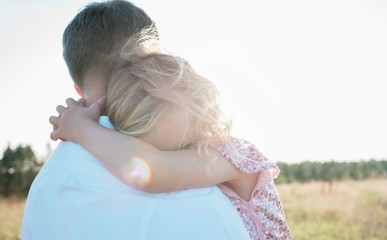 portrait of father carrying his daughter in a sparkly dress at sunset