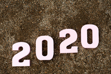 Creative inspiration concepts 2020 with pink text number with beach sand background. Business...