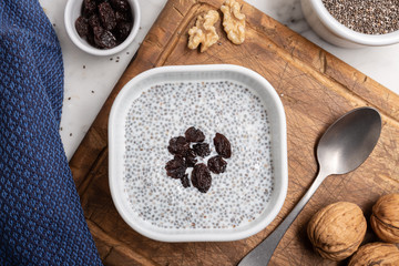 Chia seeds with milk and raisins. Chia pudding on table. Super food