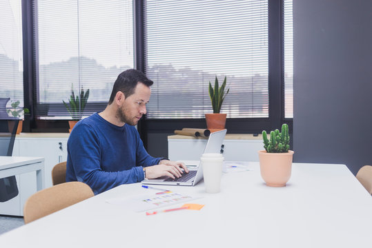 Bearded Man working on laptop in office