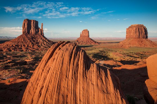 Sunset light hits the iconic rock formations in Monument Valley, AZ