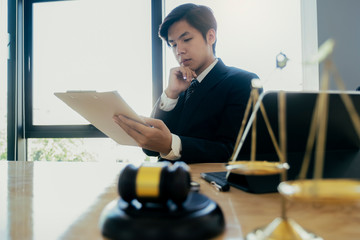 Male lawyer in the office with brass scale.