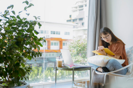 Collage student female reading and researching form book.
