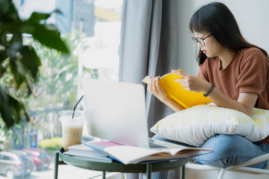 Collage student female reading and researching form book.