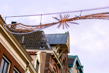 Winter holidays christmas decoration and ancient Dutch facades and roofs in city. 