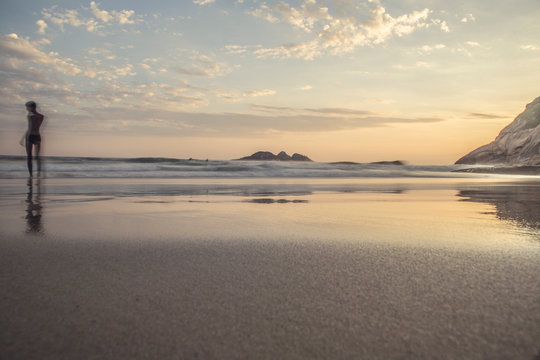 Boy in the sea shore during sunset at Joatinga beach