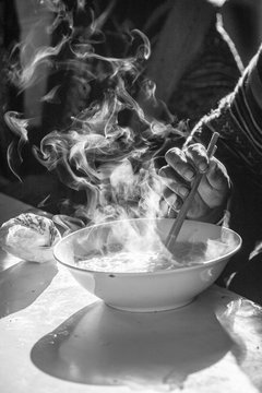 Hmong woman taking a steaming pho bowl (vietnamese soup)