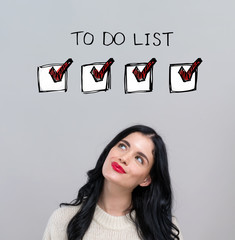 To do list with happy young woman on a gray background