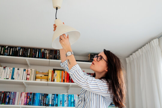 Woman fixing lamp