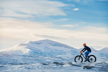 Man cycling in winter landscape