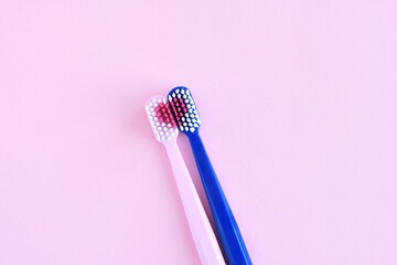 Toothbrush for personal healthcare dental care on pink background.Two bright toothbrushes with red...