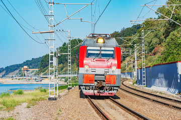 Obraz premium Passenger train moves along the mountains and Black sea.