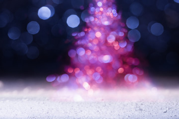 Fototapeta na wymiar Defocused holiday lights in the shape of Christmas tree. New Year greeting