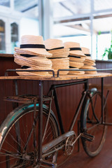 Fototapeta na wymiar stack of straw hats on top of a bicycle at a weeding