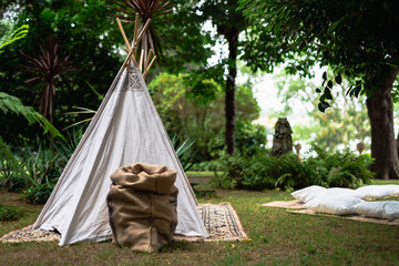 Small tipi indian tent with pillows in the woods