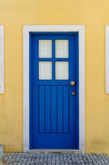 Fototapeta na wymiar Beautiful blue gate with a yellow facade