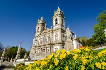 Fototapeta na wymiar Sanctuary of Bom Jesus do Monte with a yellow flowers under a blue sky