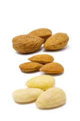 mandorle con guscio, buccia e senza all'interno di una ciotola di vetro su uno sfondo bianco