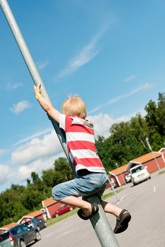 Boy climbing pole