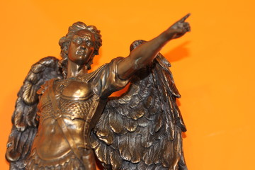 bronze sculpture of Archangel Michael with wings and sword