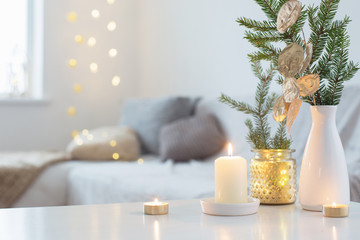 Christmas decorations with burning candles in white interior