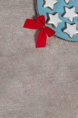 Cinnamon star cookies on a plate surrounded by Golden Christmas ornaments on a  Sackcloth tablecloth flat or top view 