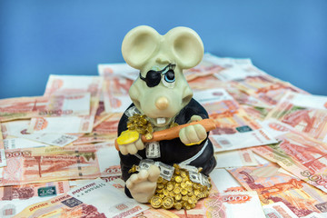 The piggy Bank rat is sitting on money.The symbol of the New year