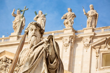 Statue of Apostle Paul with a sword in front of the St Peter's Basilica, Rome, Italy during summer sunny day. Facade exterior in Vatican city.