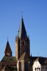 Fototapeta premium Die Kirche St. Peter und Paul in Wissembourg mit einem alten Haus