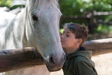 Niño con su mejor amigo, su caballo blanco.  - obrazy, fototapety, plakaty