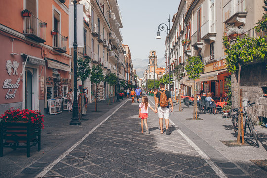 Fototapeta Happy mother and little adorable kid on cozy street during italian vacation.