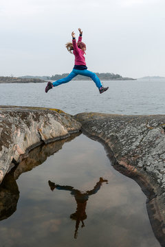 Girl jumping at lakeshore
