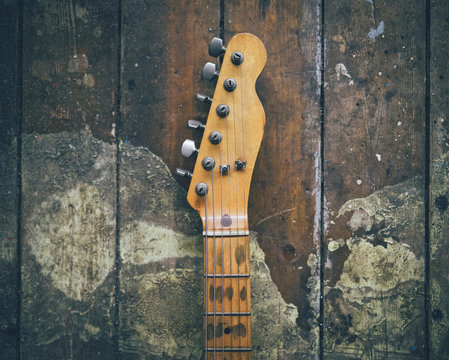 Guitar head against old wall