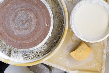 Potters wheel used for making ceramics and a bowl of coloured glaze for adding colour and decoration
