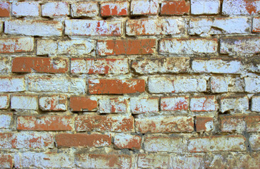  Old brickwork of red-orange color, painted on top with white paint. Bricks are located end to the viewer.
