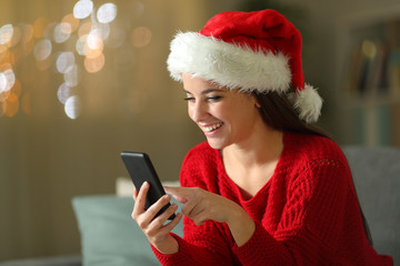 Happy woman checks mobile phone at christmas