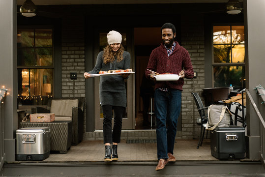 Dinner party hosts delivering food platters