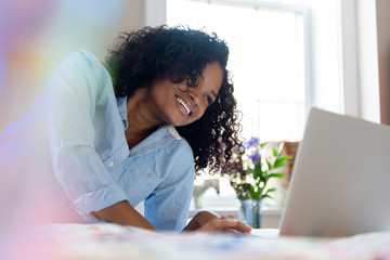 Woman using laptop in bed