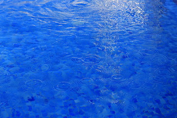 Fototapeta premium The background is blue clear water in the pool with waves and glare of light