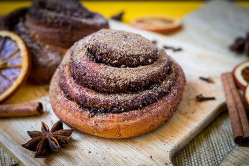 Lush cinnamon rolls with aromatic spices on vintage brick background 