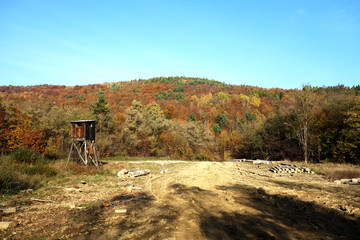 Abandoned hunting tower in the forest in autumn time