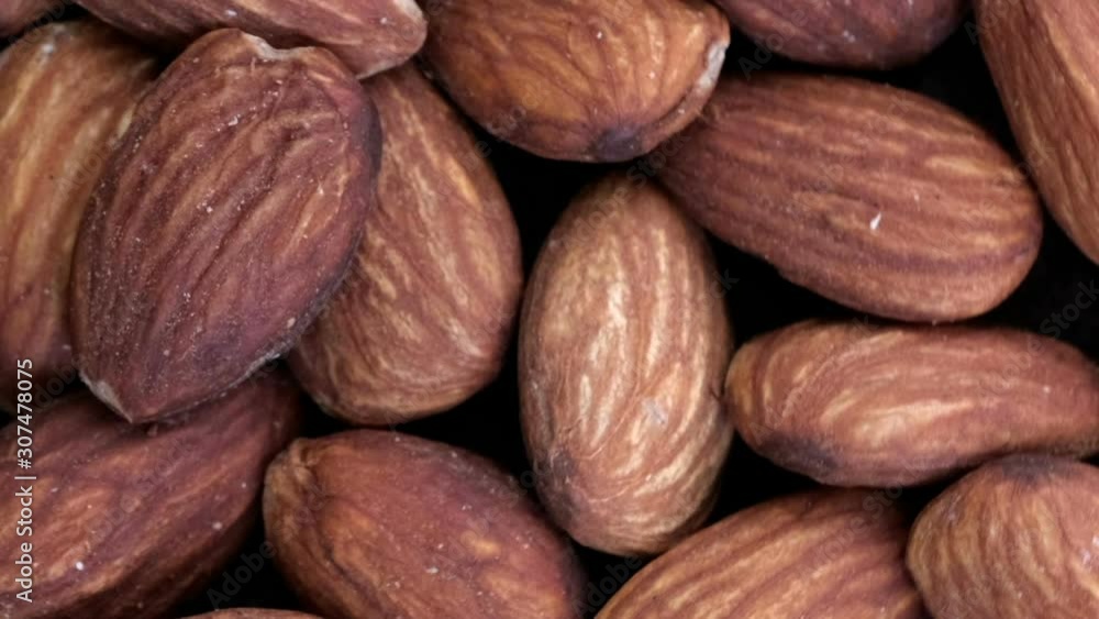 Poster grocery video screen saver, rotating background from almond kernels macro close-up top view using zo