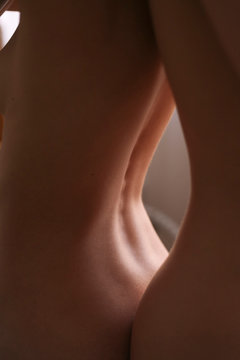 photo of the naked back of a girl close in soft light