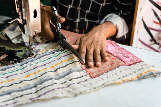Crop ethnic sewer making ornamental bag