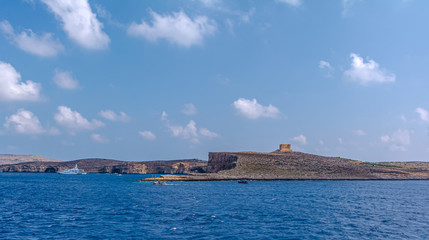 Saint Mary's Tower, or Comino Tower, shot from the water. It is large bastioned watchtower on Comino island, Malta. Now it is staging post to guard against illegal hunting of birds in sea.