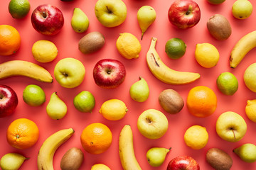 Colorful assortment of fruit on pink backdrop