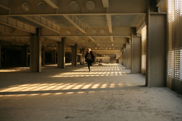 teenager runs in an abandoned parking lot