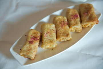 Pancakes filled with meat filling on a brown dish on plate . Pancake. Thin pancakes with fillings.